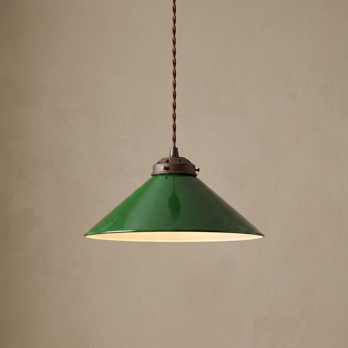 Green enamel conical pendant light with a bronze fixture hanging against a textured beige background.