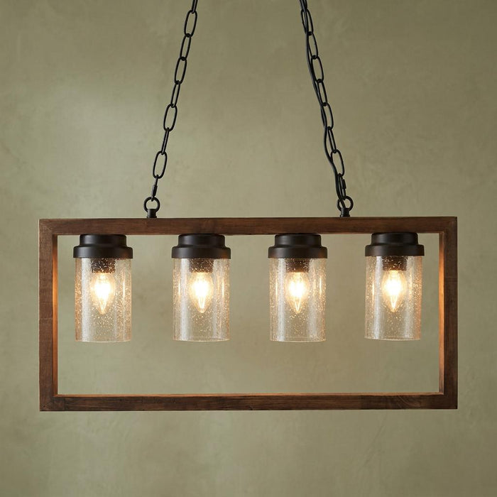Four-light rectangular wood frame ceiling pendant with seeded glass shades hanging from black chains.