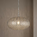 Intricate nickel fretwork pendant light with an oval shade hanging from a chain against a neutral wall.