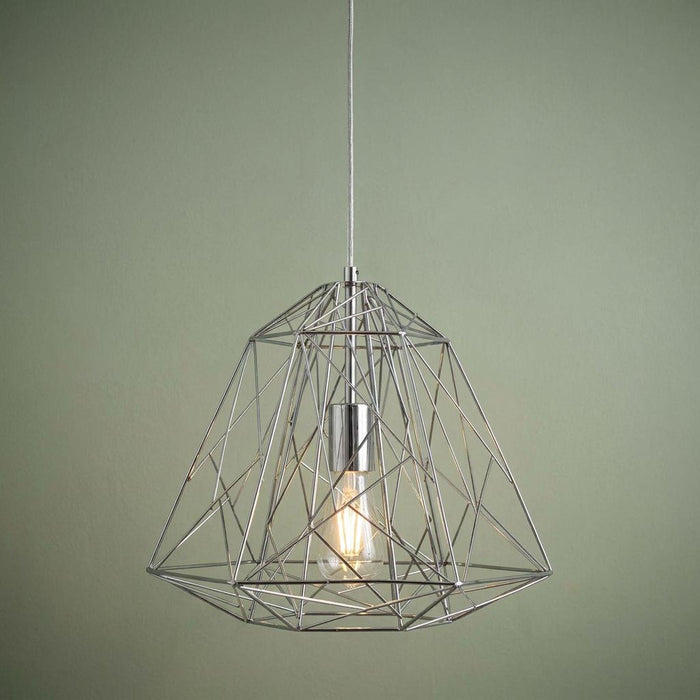 Geometric cage pendant light in chrome with an exposed bulb against a green background.