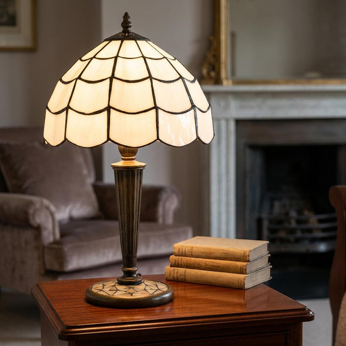Georgia Tiffany table lamp with a cream scalloped glass shade on a wooden side table in a cozy living room setting.