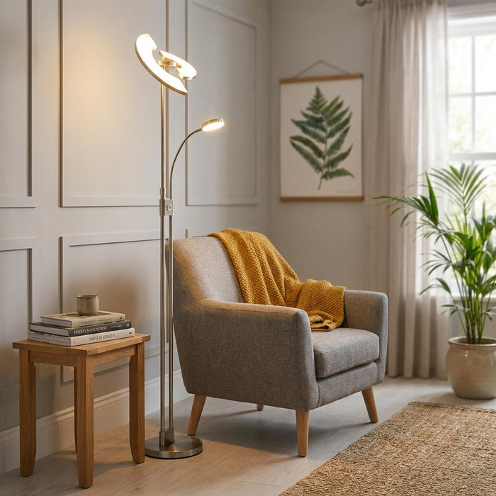 Nickel and chrome LED mother and child floor lamp illuminating a cozy living room corner next to a gray armchair.