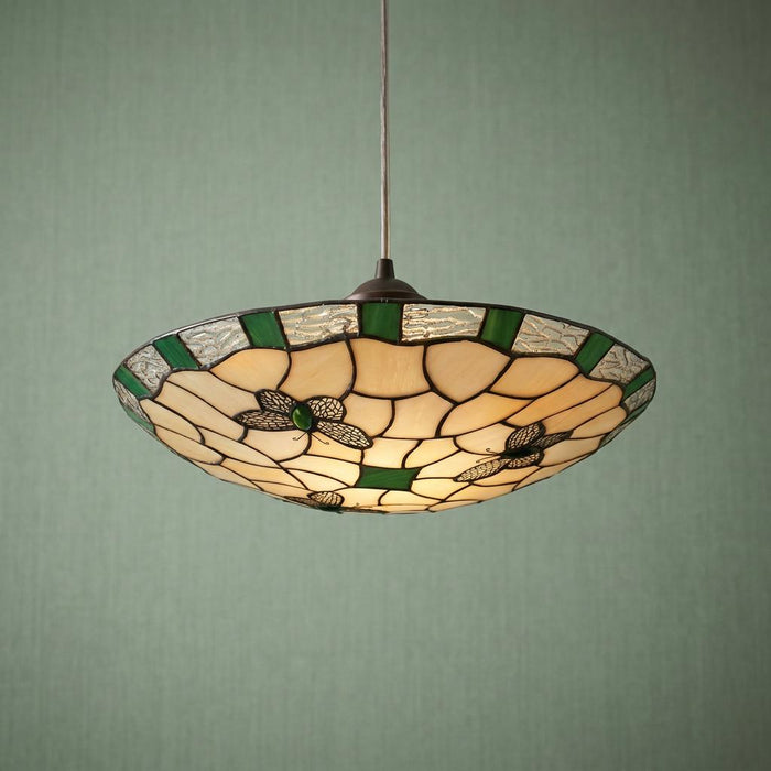 Lit Tiffany-style ceiling lamp shade featuring green butterfly stained glass motifs against a textured green wall.