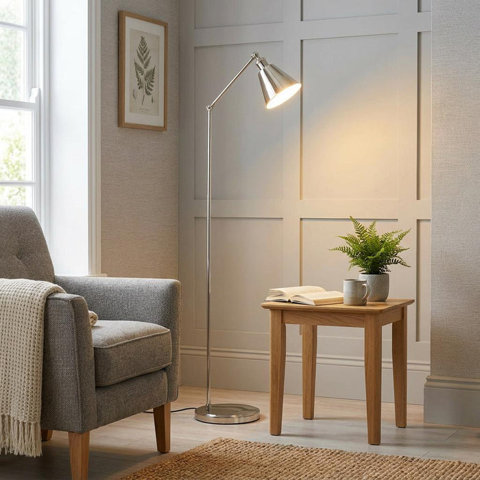 Hal Modern Nickel Floor Reading Lamp illuminating a cozy living room nook with a grey armchair and wooden side table.