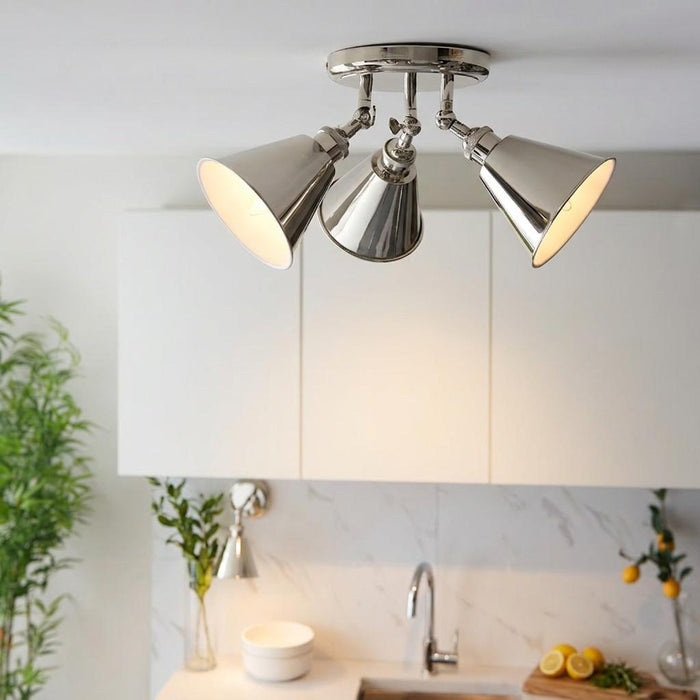 A Hal Nickel 3-light modern spotlight with polished nickel cone shades mounted on a white kitchen ceiling.