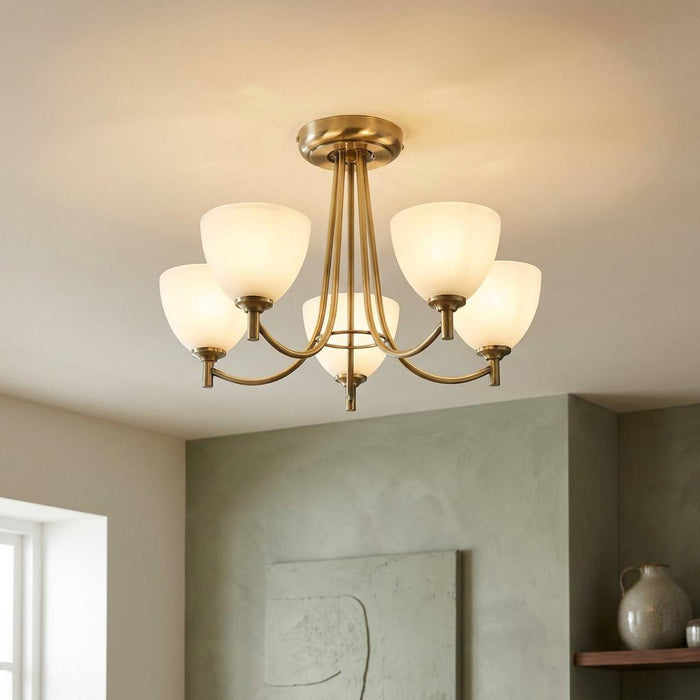 Hamburg 5-arm antique brass ceiling light with glowing frosted tulip shades in a contemporary room.