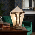 Art Deco bronze figurine lamp featuring two figures and a frosted glass panel, displayed on a wooden table.