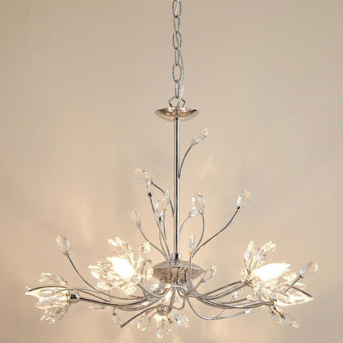 Hibiscus 5 light chrome and crystal ceiling pendant with floral branch-like arms and crystal accents against a plain wall.