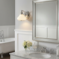 Ainsley 1-light polished chrome wall sconce with a white glass shade mounted next to a bathroom mirror.
