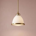 Hinkley Amelia medium brass pendant light with frosted glass dome shade and etched lens against a dusty pink wall.