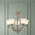 Hinkley Bolla brushed nickel 5-light chandelier with frosted opal shades against a light green paneled wall.