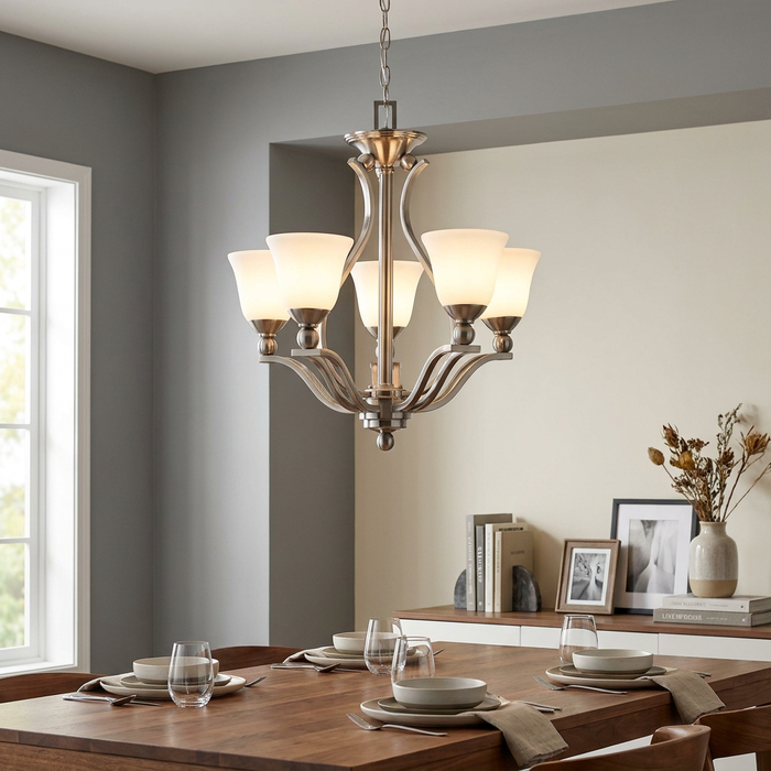 Brushed nickel five-light chandelier with opal glass shades hanging above a set wooden dining table.
