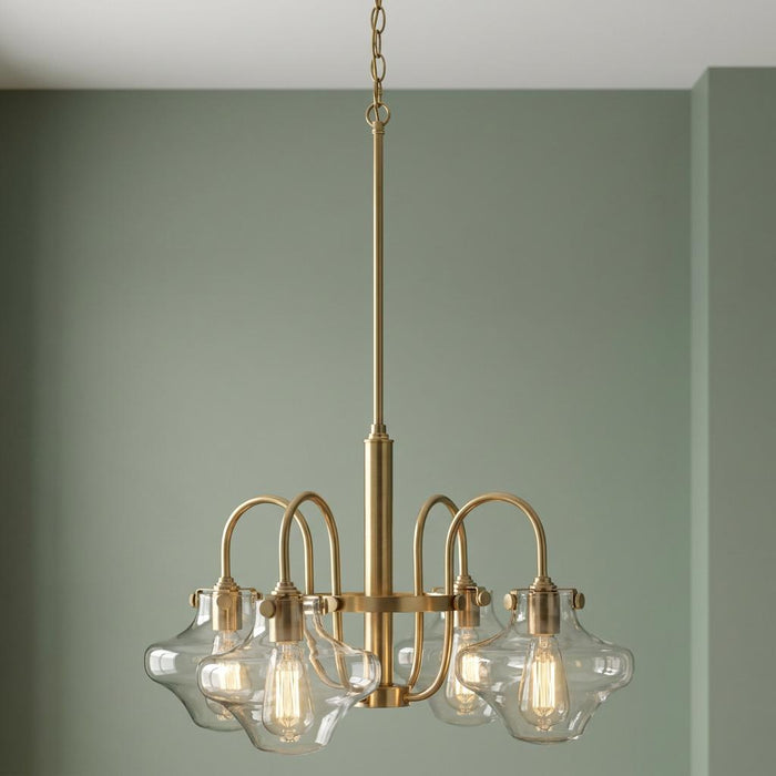 Hinkley Congress brushed brass chandelier with four clear glass shades and Edison bulbs against a sage green wall.