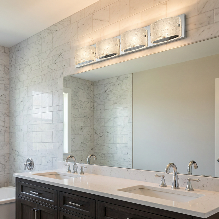 Four-light polished chrome vanity fixture with seeded glass shades mounted above a bathroom mirror.