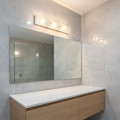 Hinkley Duet 3-light chrome wall light mounted above a large mirror in a modern, grey-tiled bathroom.