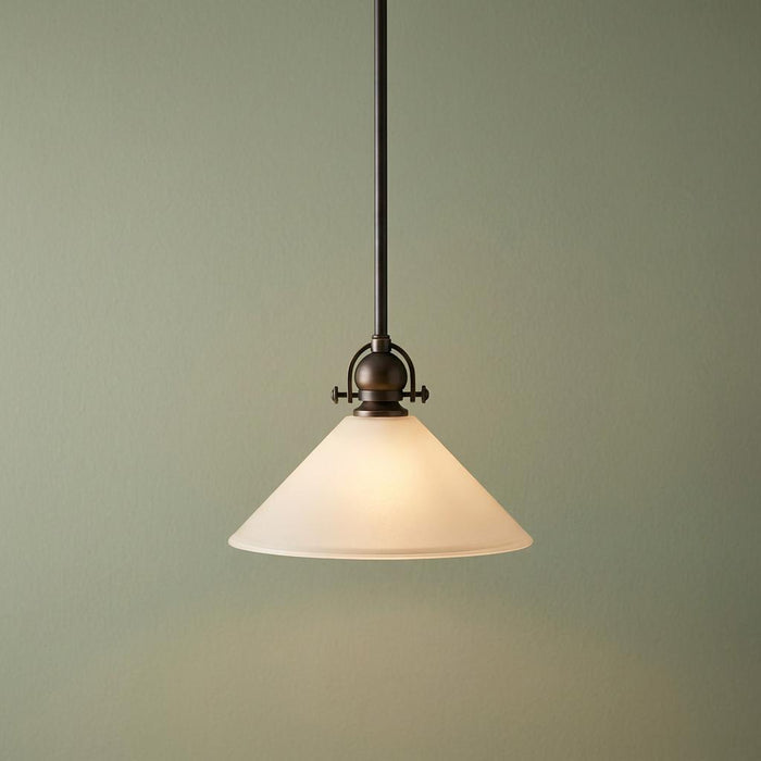 Bronze pendant ceiling light with a conical etched white glass shade against a soft green background.