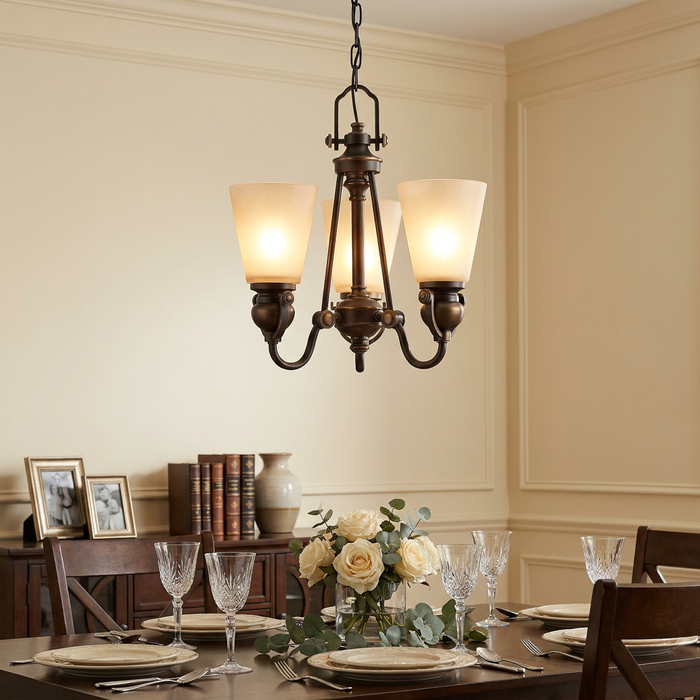 A bronze three-light chandelier with frosted glass shades hangs above a formal dining table with white roses.