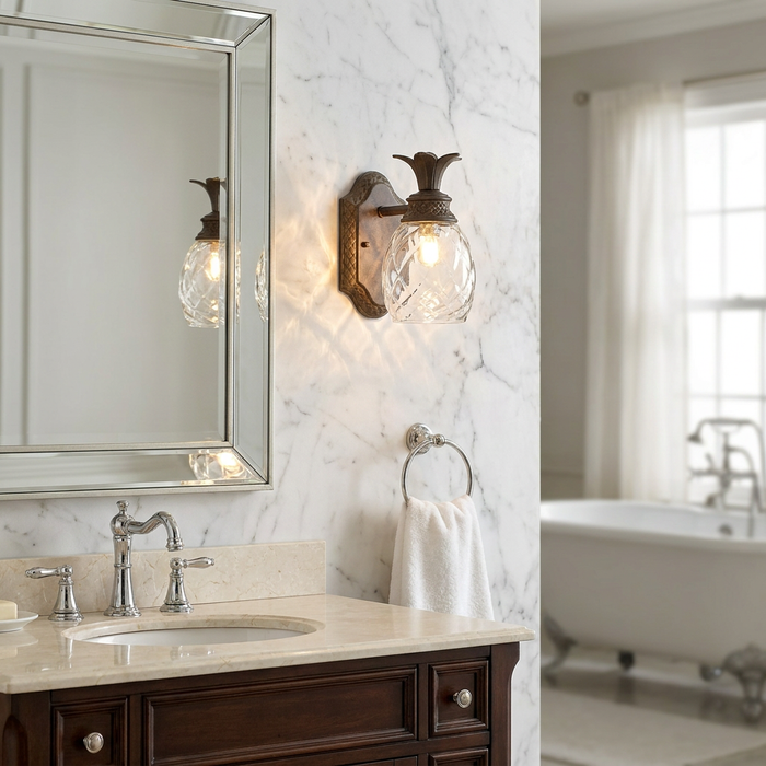 Hinkley Plantation pearl bronze wall light with a pineapple-shaped glass shade mounted on a white marble bathroom wall.