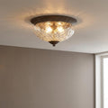 Hinkley Plantation bronze flush ceiling light with pineapple-patterned glass shade casting light onto a white ceiling.