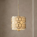 Hinkley Sabina pendant light with a geometric silver pattern over a fabric shade, hanging against a neutral wall.