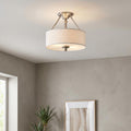 Hinkley Sussex nickel semi-flush ceiling light featuring a white fabric drum shade in a modern interior setting.