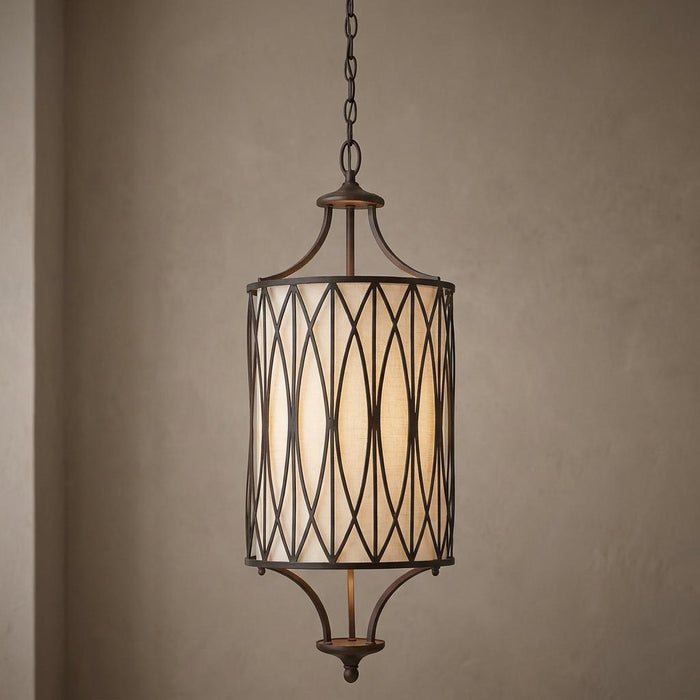 Cylindrical pendant light with a Victorian bronze lattice frame and an inner cream fabric shade.