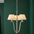 Hinkley Whitney 3-light chandelier in brushed nickel with fabric shades against a dark green wall.
