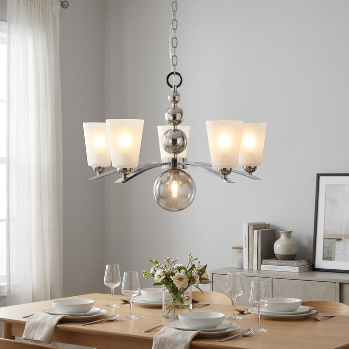 Hinkley Zelda 5-light polished nickel chandelier with frosted shades hanging over a wooden dining table.