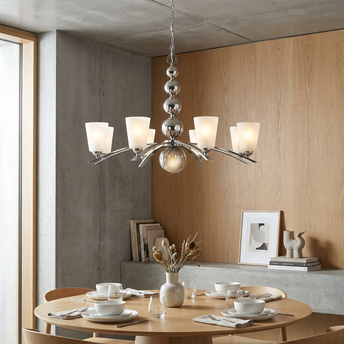 Hinkley Zelda 8 light polished nickel chandelier with frosted glass shades hanging over a modern dining table.