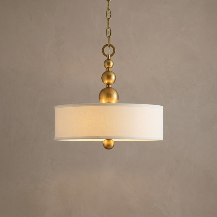 Mid-century modern vintage brass pendant light with a white drum shade and stacked sphere details.