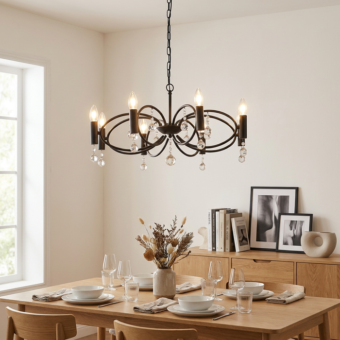 Black Infinity 8-light pendant chandelier with crystal glass droplets hanging above a wooden dining table.
