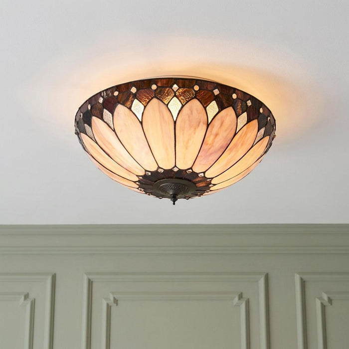 Large flush Tiffany ceiling light with a warm Art Deco stained glass petal design mounted on a white ceiling.