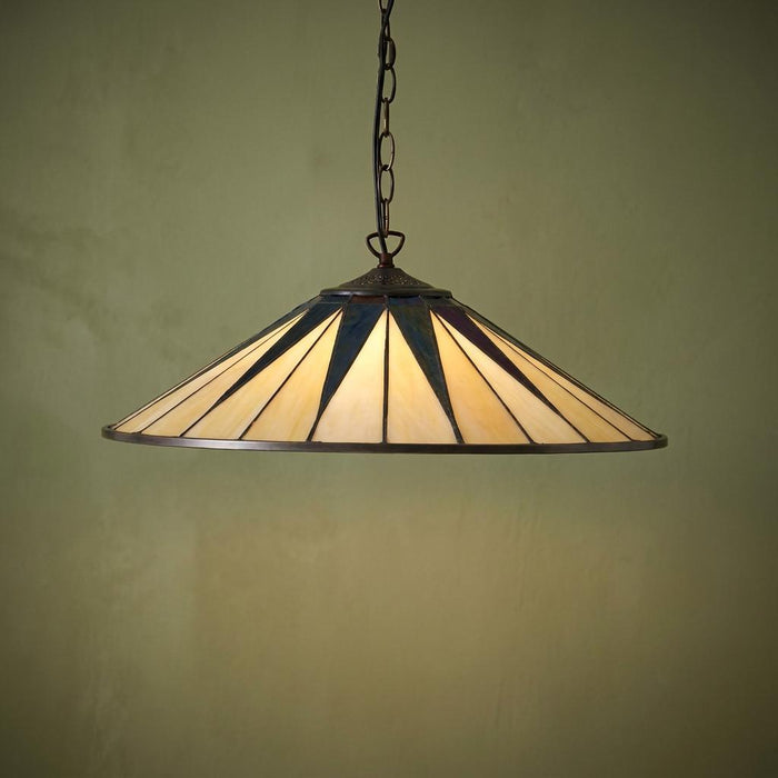 Large Tiffany ceiling pendant with a cream and dark blue star-patterned glass shade hanging against a green wall.