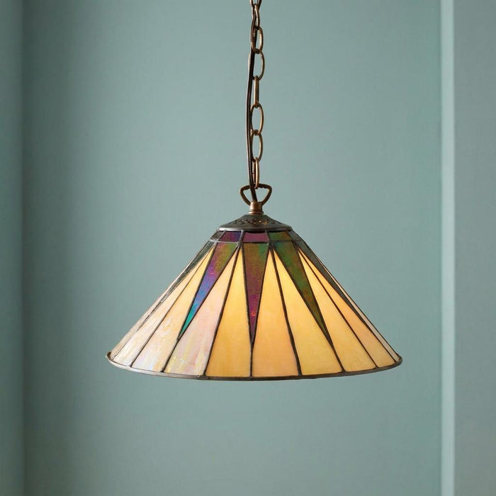 A small Tiffany pendant light with an iridescent cream and purple starburst glass shade against a teal wall.