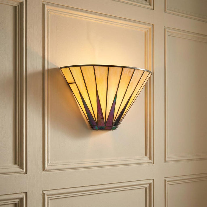 Tiffany-style fan wall light with iridescent glass details glowing on a cream-paneled wall.