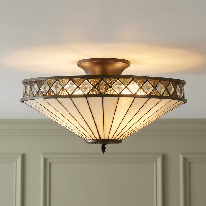 Art Deco semi-flush Tiffany glass ceiling light with a diamond pattern border, mounted and illuminated.