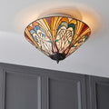 Tiffany-style flush mount ceiling light with a peacock feather pattern in amber and blue stained glass.