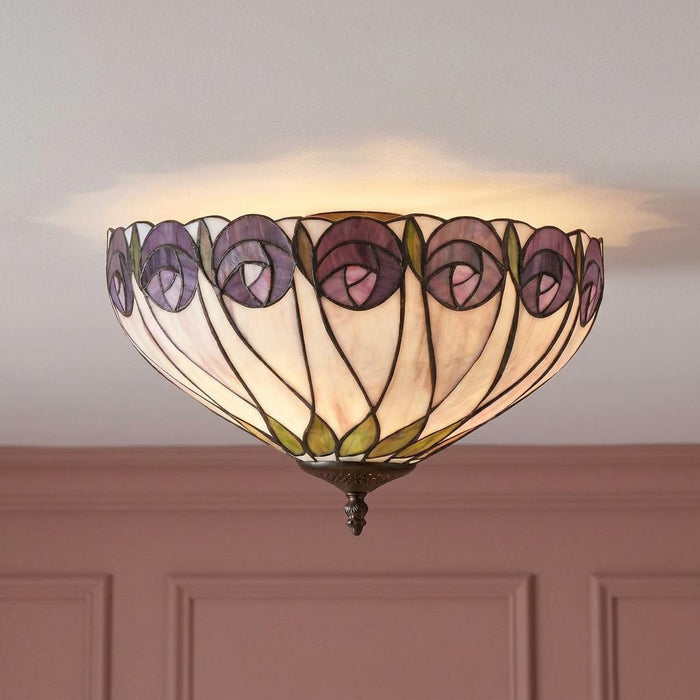 Tiffany-style flush ceiling light with purple rose patterns and green leaves, casting a warm glow on a white ceiling.