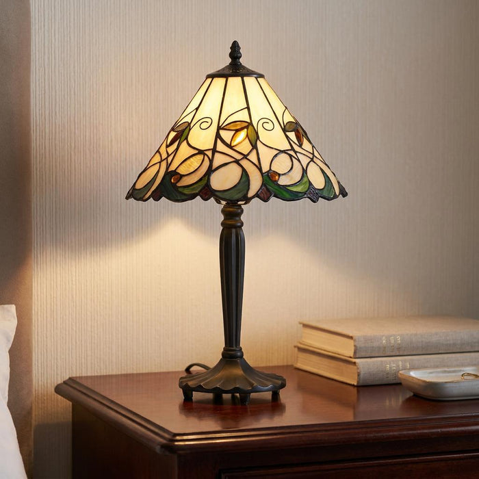 Interiors 1900 Jamelia Small Tiffany Lamp with floral glass shade on a dark wood nightstand.