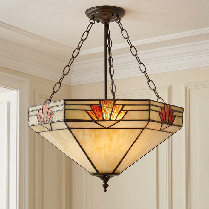 Art Deco inverted Tiffany ceiling light with a geometric cream and amber glass shade, hanging from black chains.