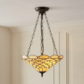 Pearl inverted Tiffany ceiling light with a scalloped cream glass shade and bronze chains in a paneled room.