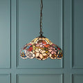 Sullivan small Tiffany ceiling light with a floral stained glass shade hanging against a teal paneled wall.