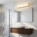 Kalmar chrome finish bathroom wall light with frosted glass mounted above a mirror in a modern marble bathroom.