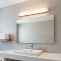 A long, horizontal bathroom wall light with a chrome finish and frosted diffuser mounted above a vanity mirror.