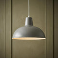 Kanya soft grey pendant ceiling light hanging against a paneled green wall.