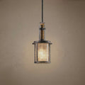 Rustic industrial pendant light with an anvil iron mesh cage and wood accents suspended against a neutral wall.