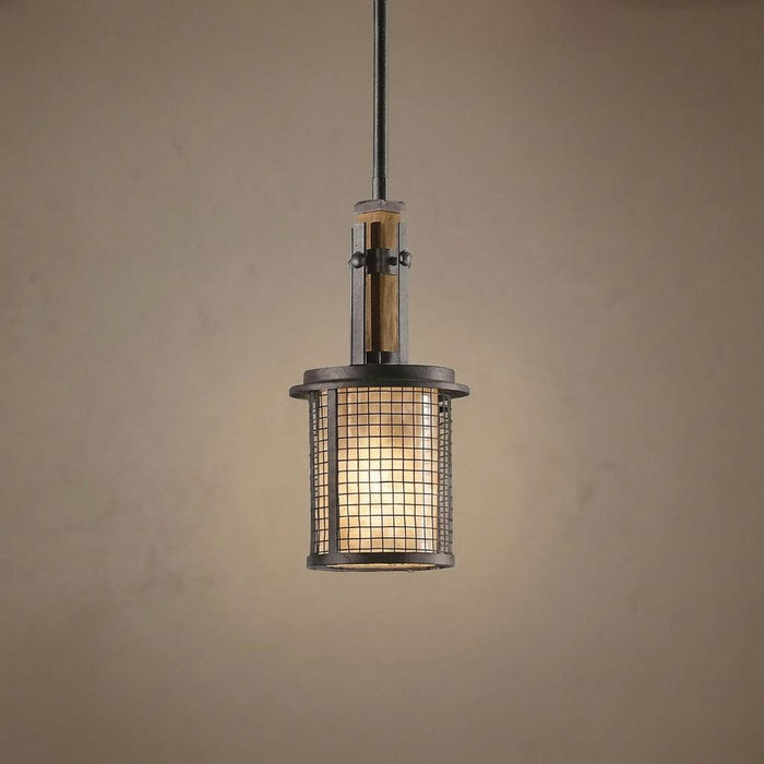 Rustic industrial pendant light with an anvil iron mesh cage and wood accents suspended against a neutral wall.