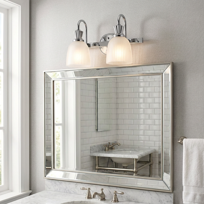 Kichler Cora polished chrome 2-light wall fixture with ribbed glass shades installed above a large bathroom mirror.