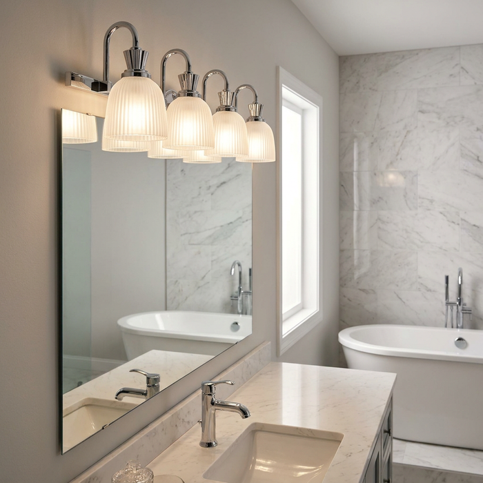 A 4-light polished chrome vanity light with ribbed frosted glass shades above a marble bathroom vanity.