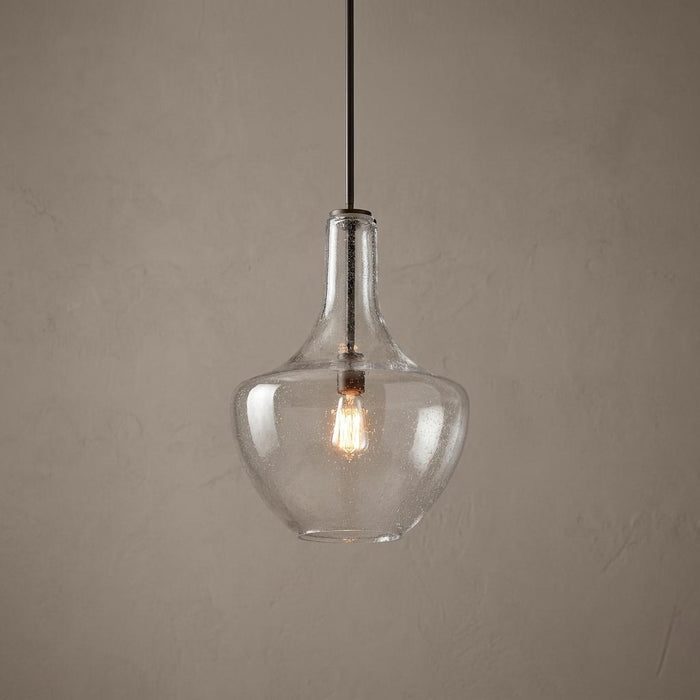Bronze ceiling pendant light featuring a bulbous clear seeded glass shade and a glowing vintage-style bulb.